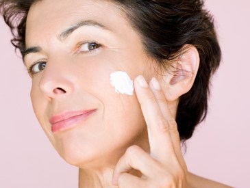 woman applying moisturizer