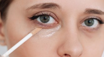 woman applying under-eye concealer
