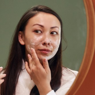woman using face exfoliant