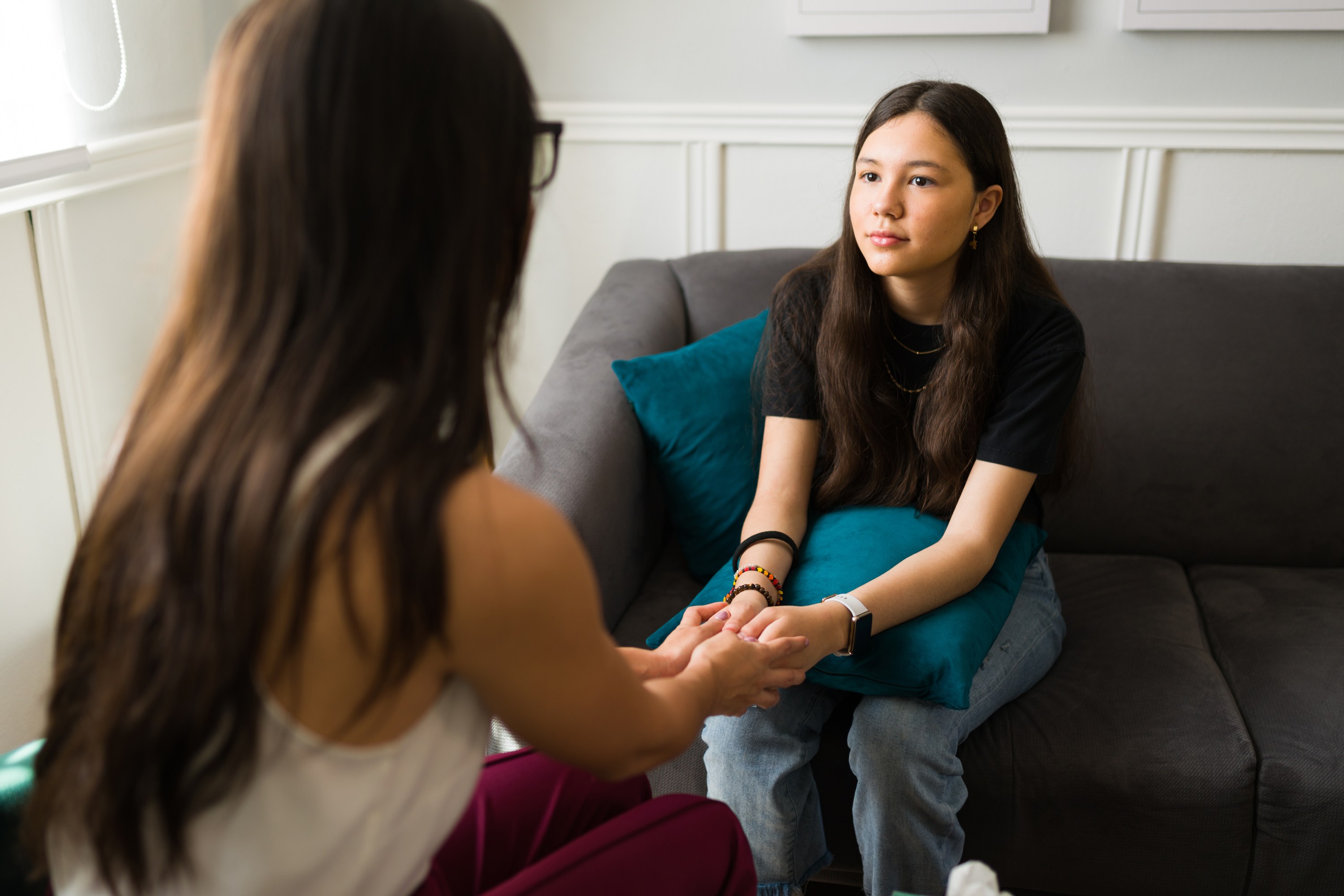 Therapist holding hands with a teen patient