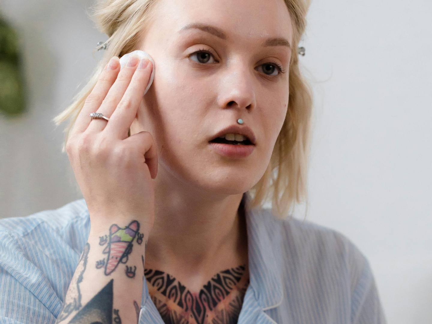 Woman in Blue Button Up Shirt Applying Make Up