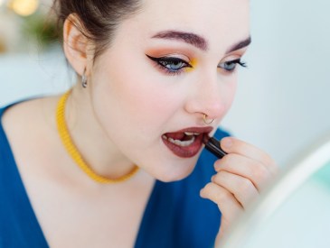 woman using '90s vampy lipstick, Revlon Super Lustrous Lipstick in Rum Raisin