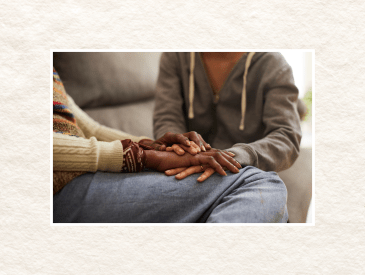 Women holding hands on a couch