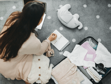 A pregnant woman prepares a bag for the hospital